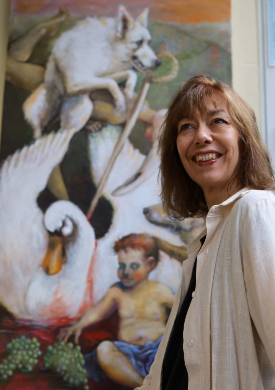 Frau vor Gemälde mit Wolf, Schwan und Kleinkind, Sabine Schinnen-Bohe